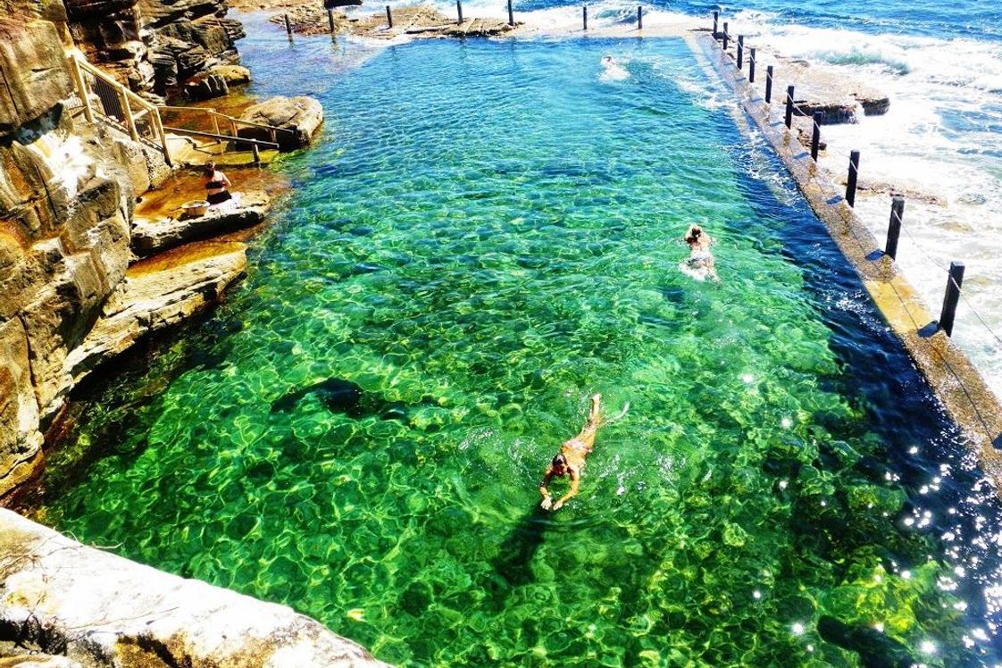 a woman swimming in emerald-coloured water at McIver's Ladies Baths in Coogee
